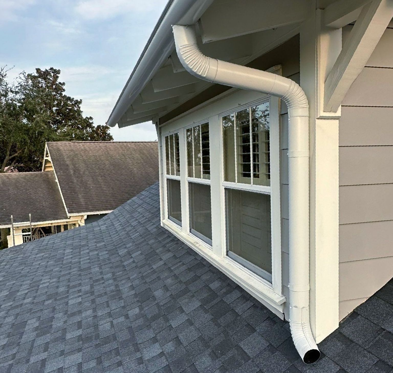 A house with a gutter and a window on the side of it.