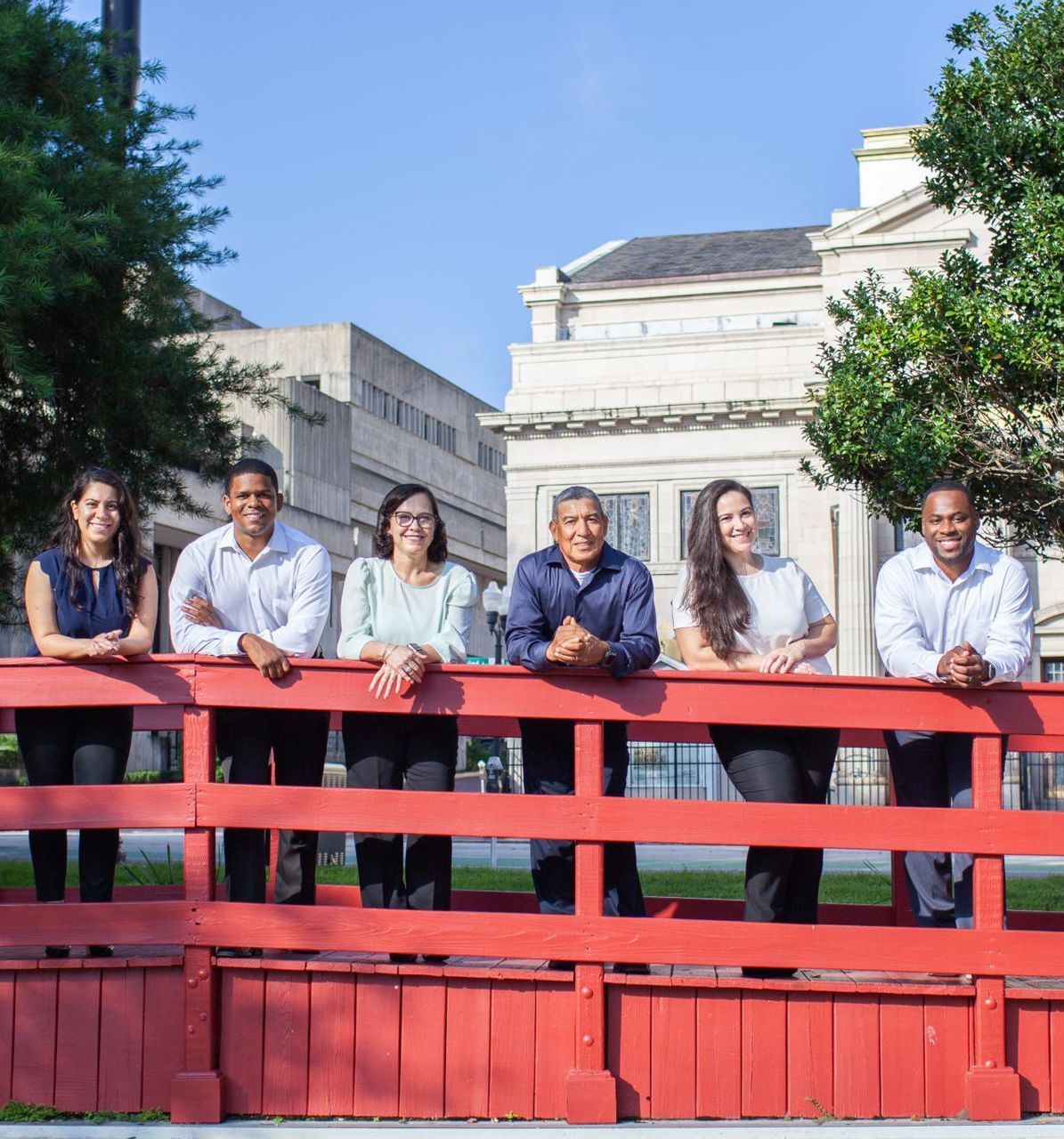 Nine Square Roofing team standing on a red bridge