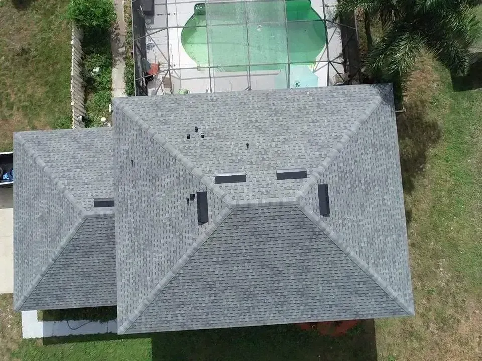 An aerial view of a roof with a pool in the background