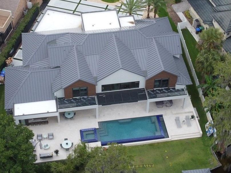 An aerial view of a house with a large pool