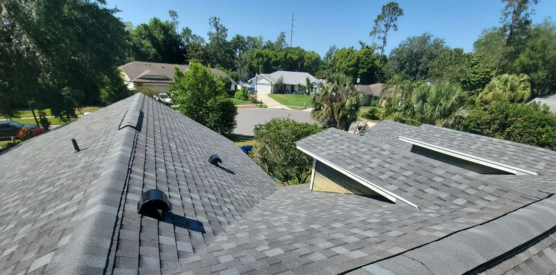 A roof with asphalt shingles on it in a residential area.