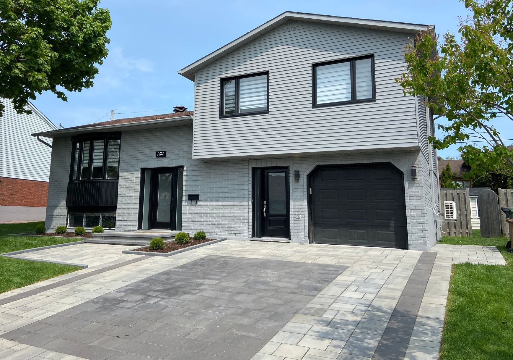 Une grande maison blanche avec une porte de garage noire