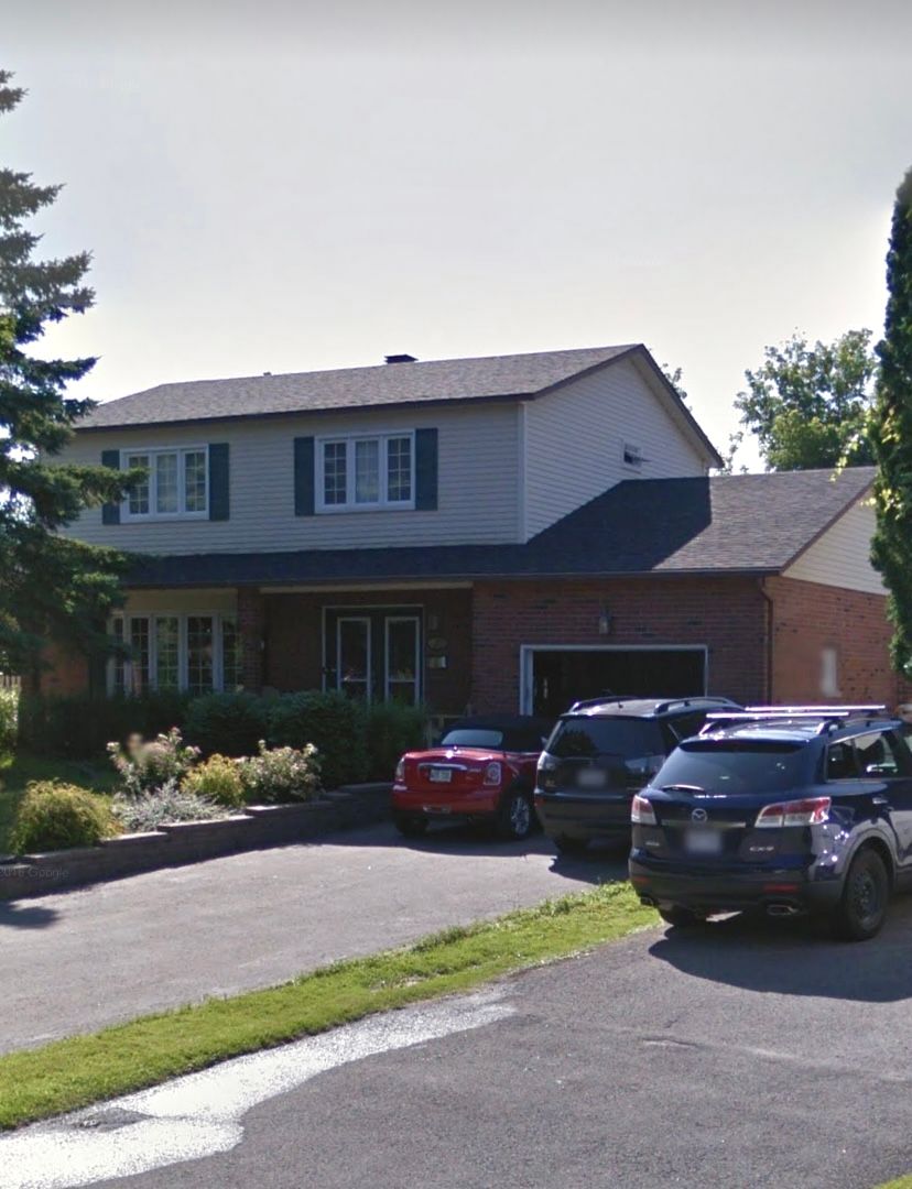 Une maison avec beaucoup de voitures garées devant