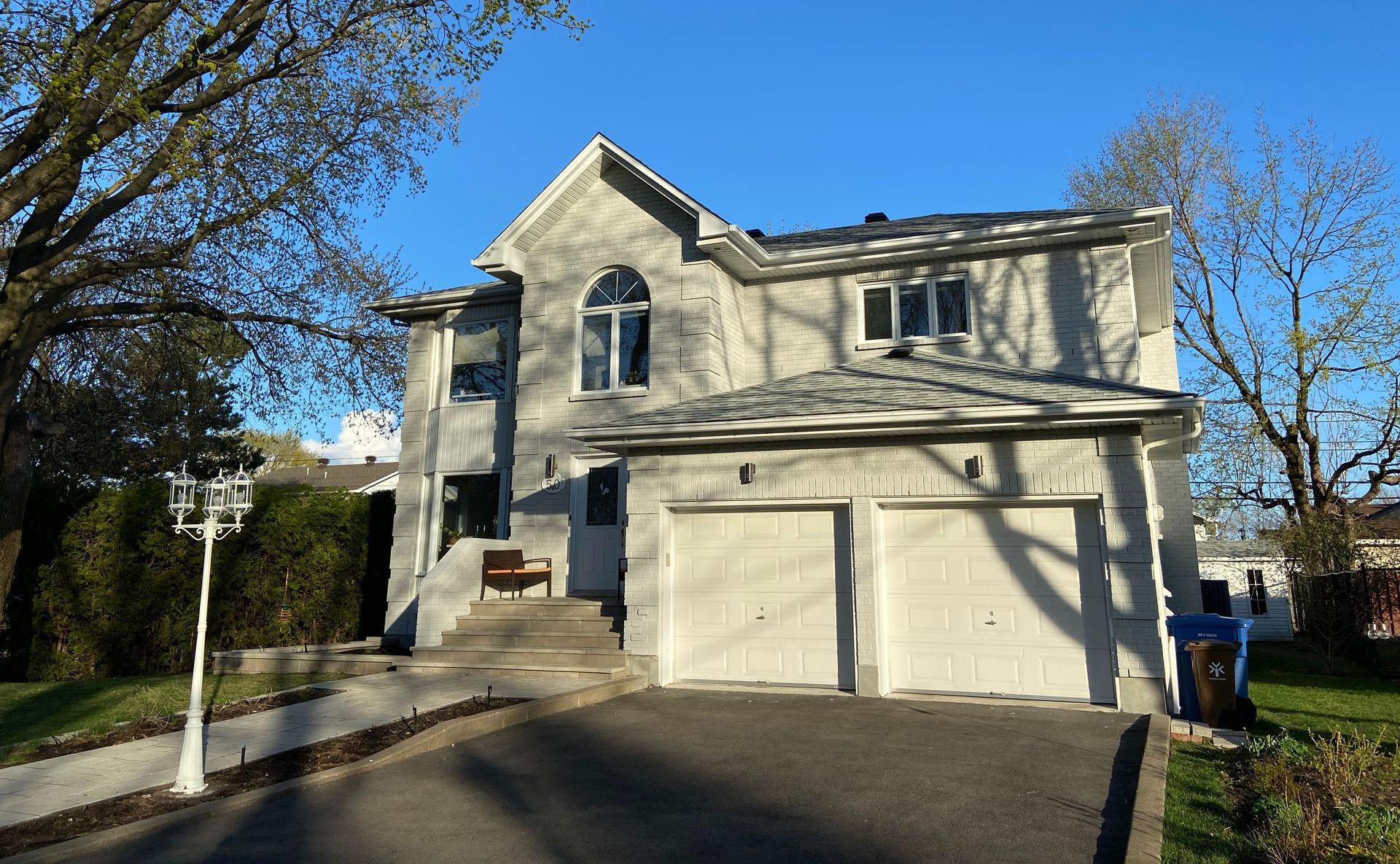 A large white house with two garage doors and a driveway