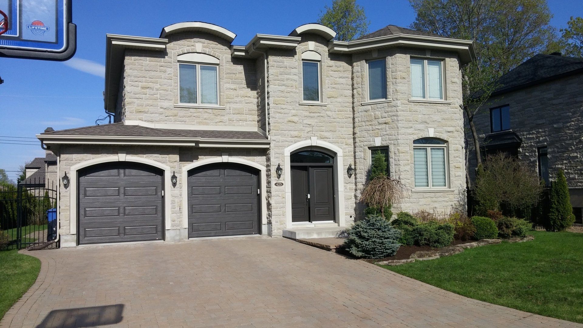 A large brick house with two garages and a driveway