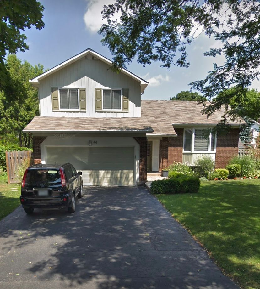 Une voiture est garée devant une maison en brique