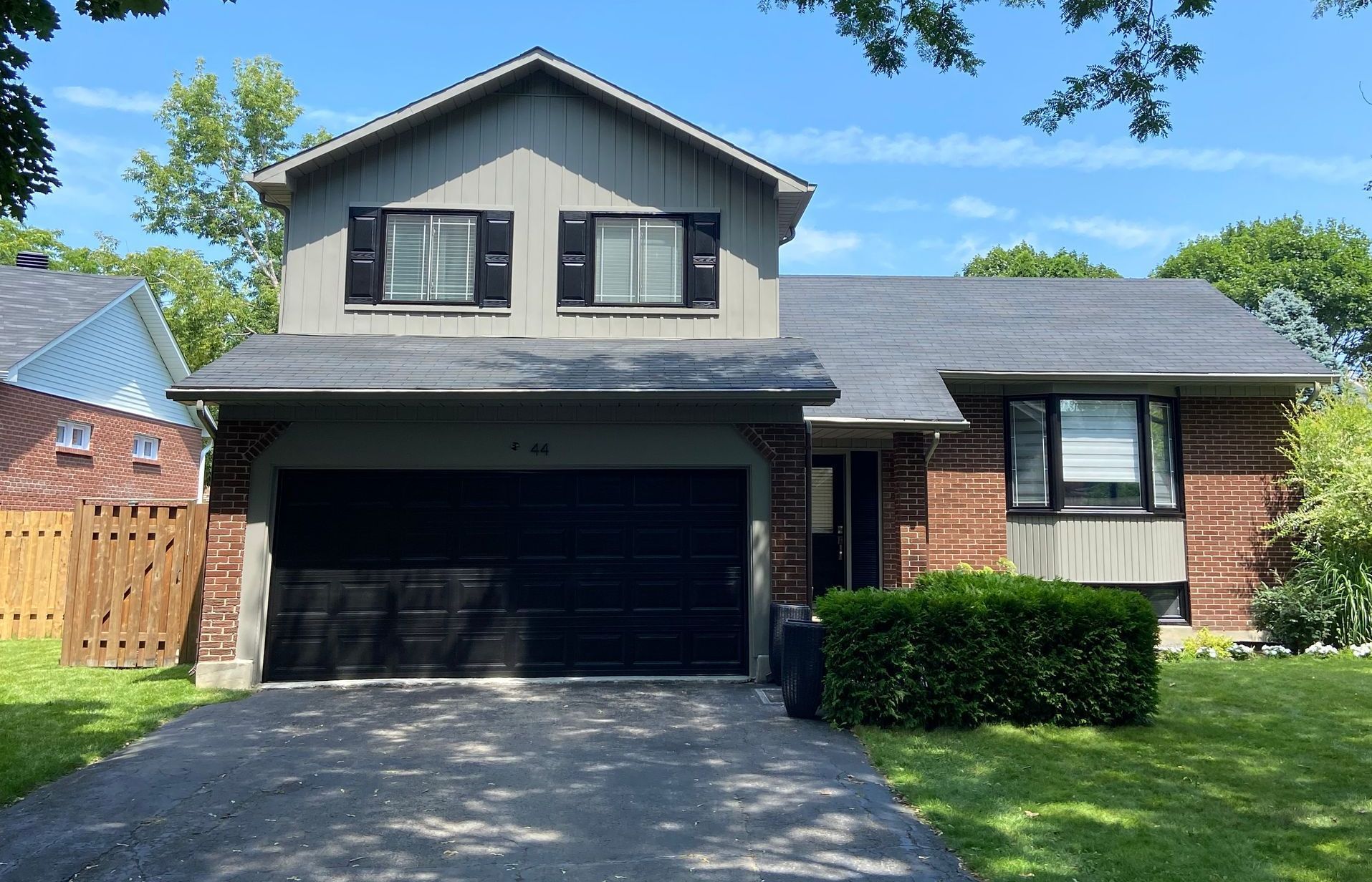 Une maison en brique avec un garage et une allée