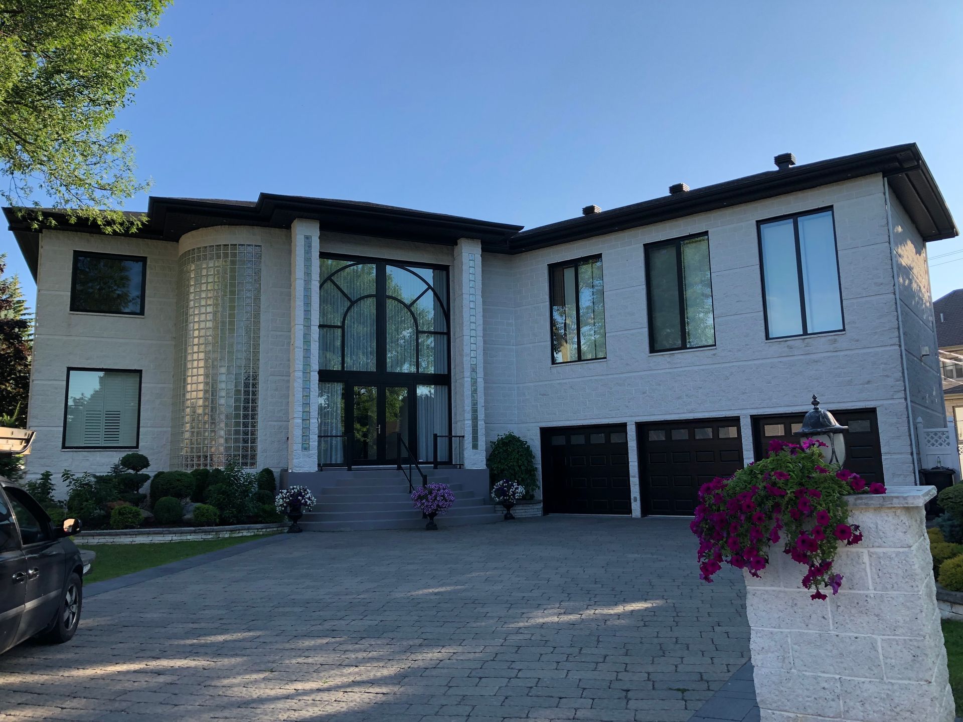 A large white house with a car parked in front of it.