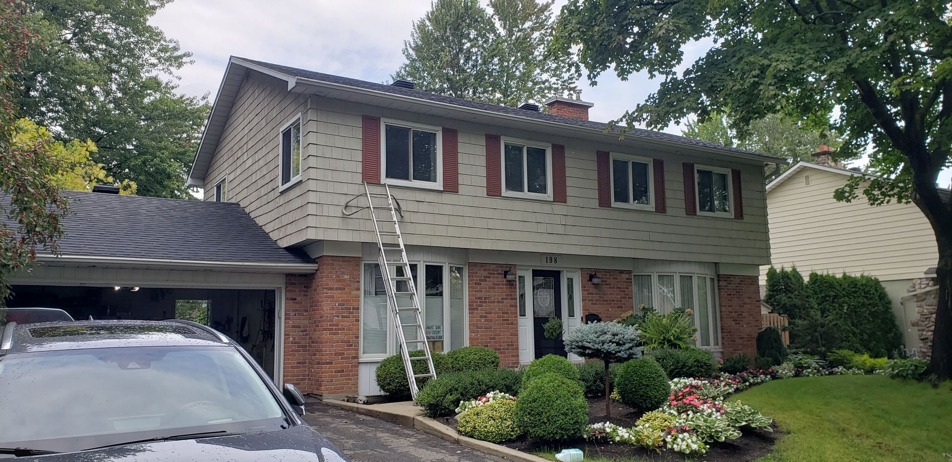 Une maison avec une voiture garée devant.