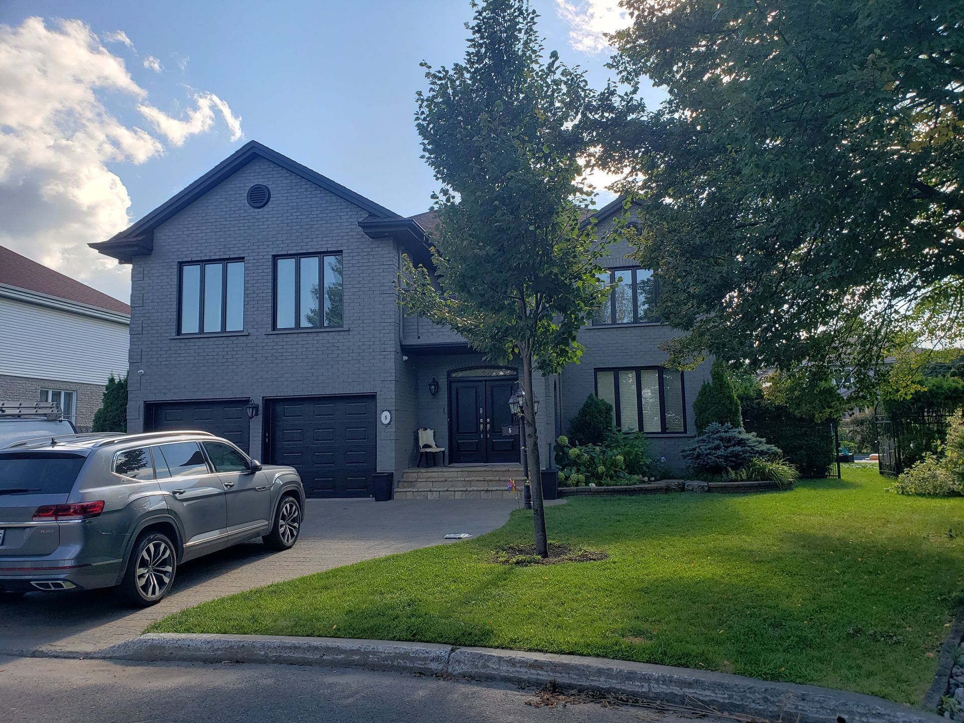 Une voiture est garée devant une grande maison.