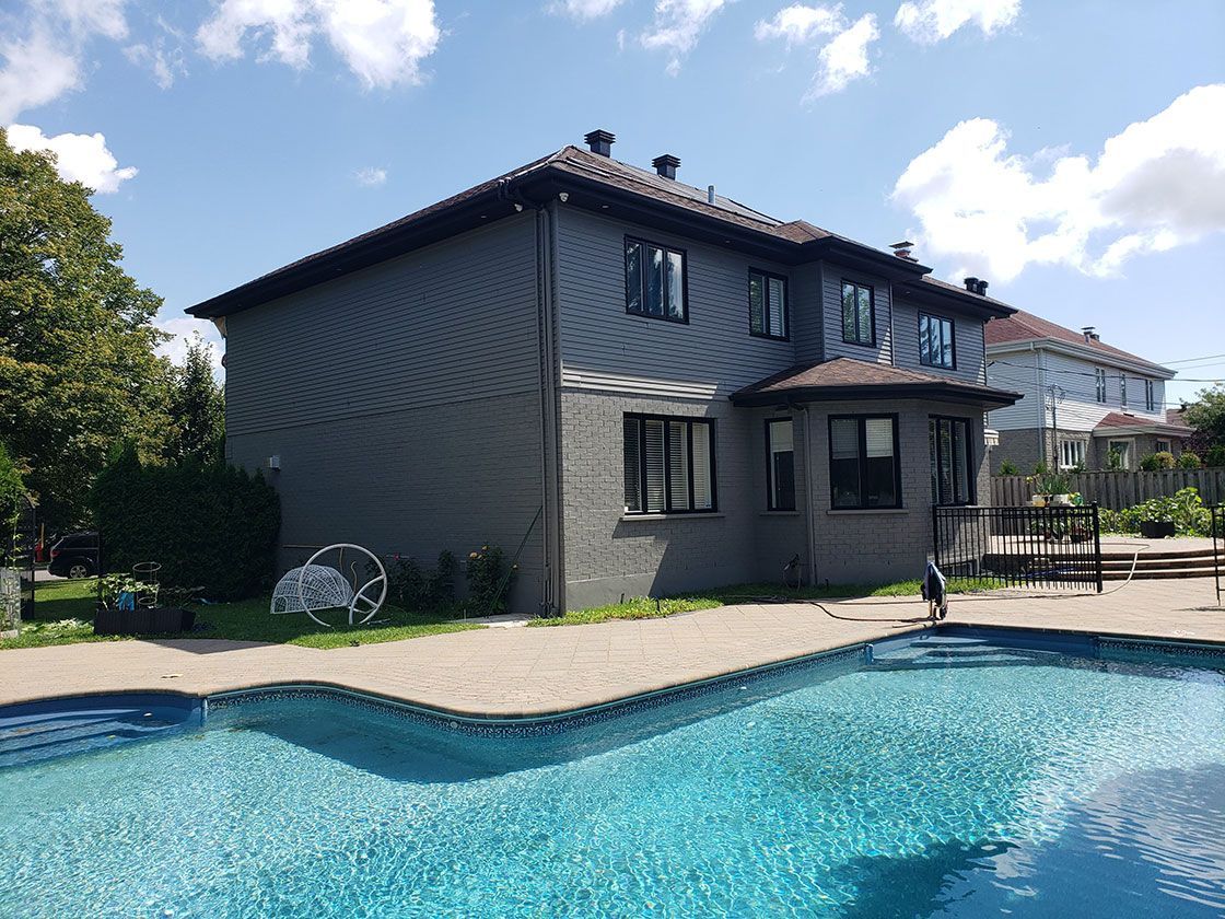 Une grande maison avec une grande piscine devant.