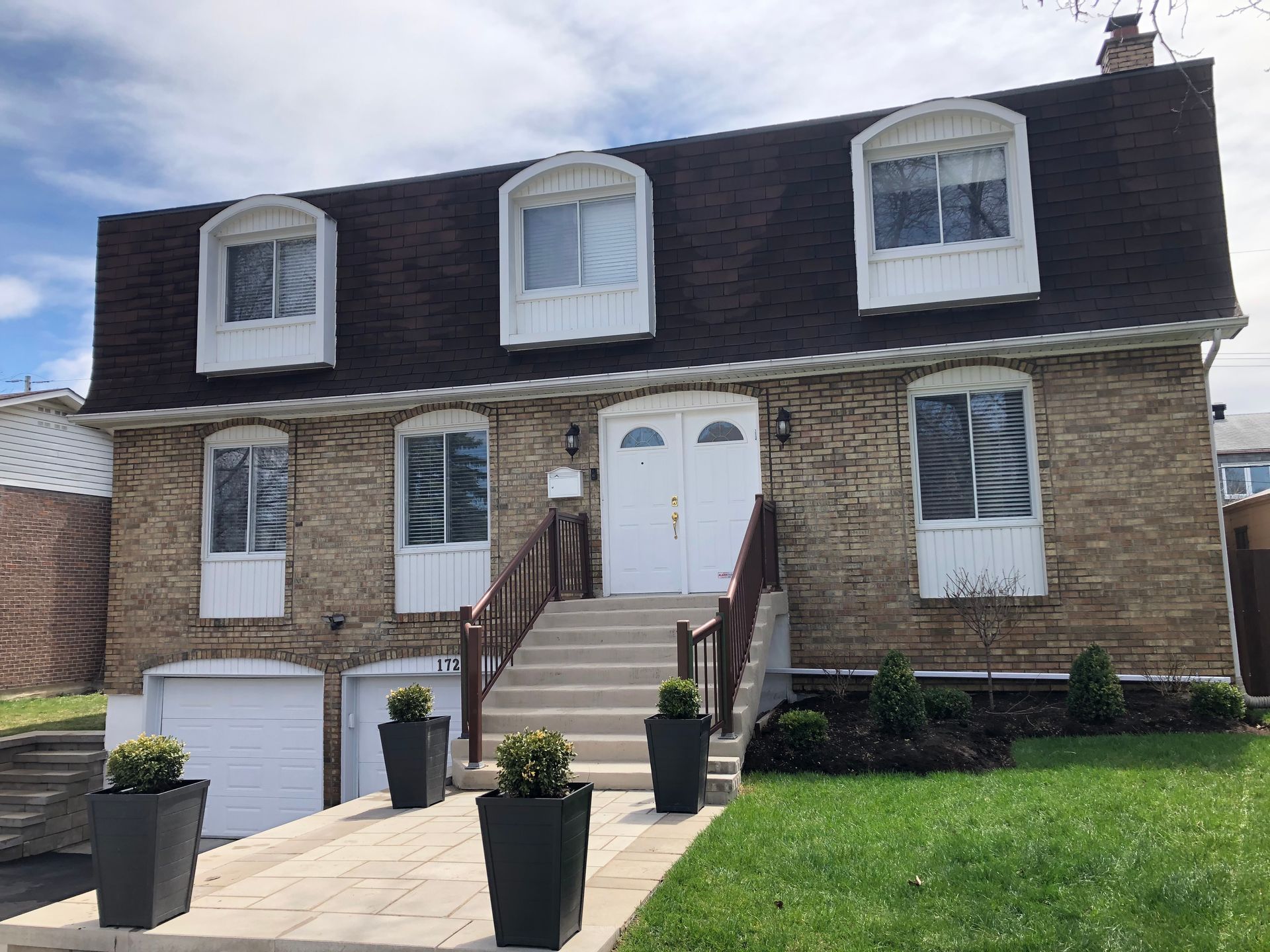 Une grande maison en brique avec des escaliers menant à la porte d'entrée