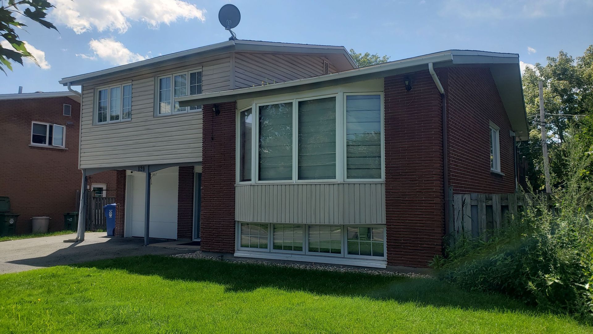 Une grande maison en brique avec de nombreuses fenêtres se trouve au sommet d'une pelouse verdoyante.