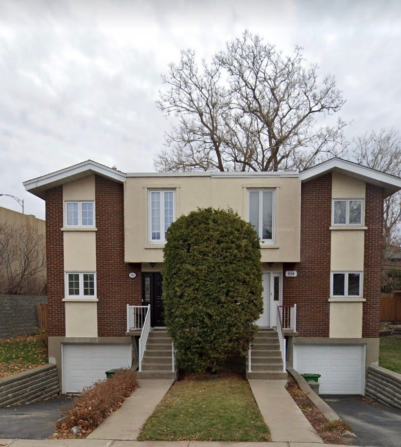 Une maison avec deux garages et un escalier qui y mène