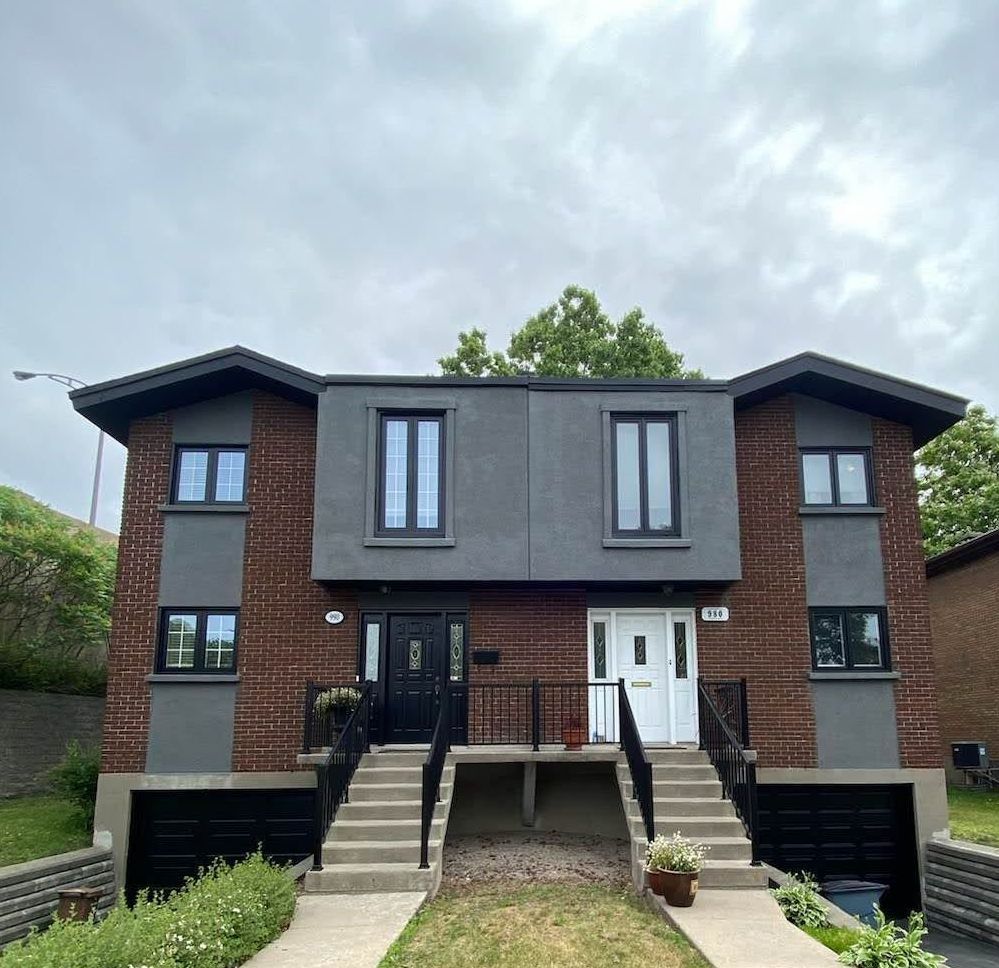 Une maison en brique avec des escaliers menant à la porte d'entrée