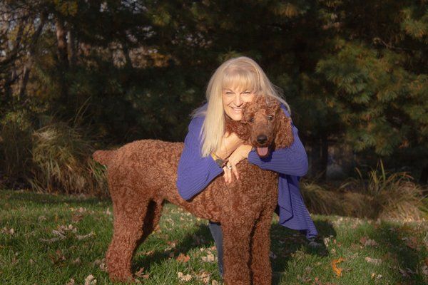 Charlotte hugging brown dog