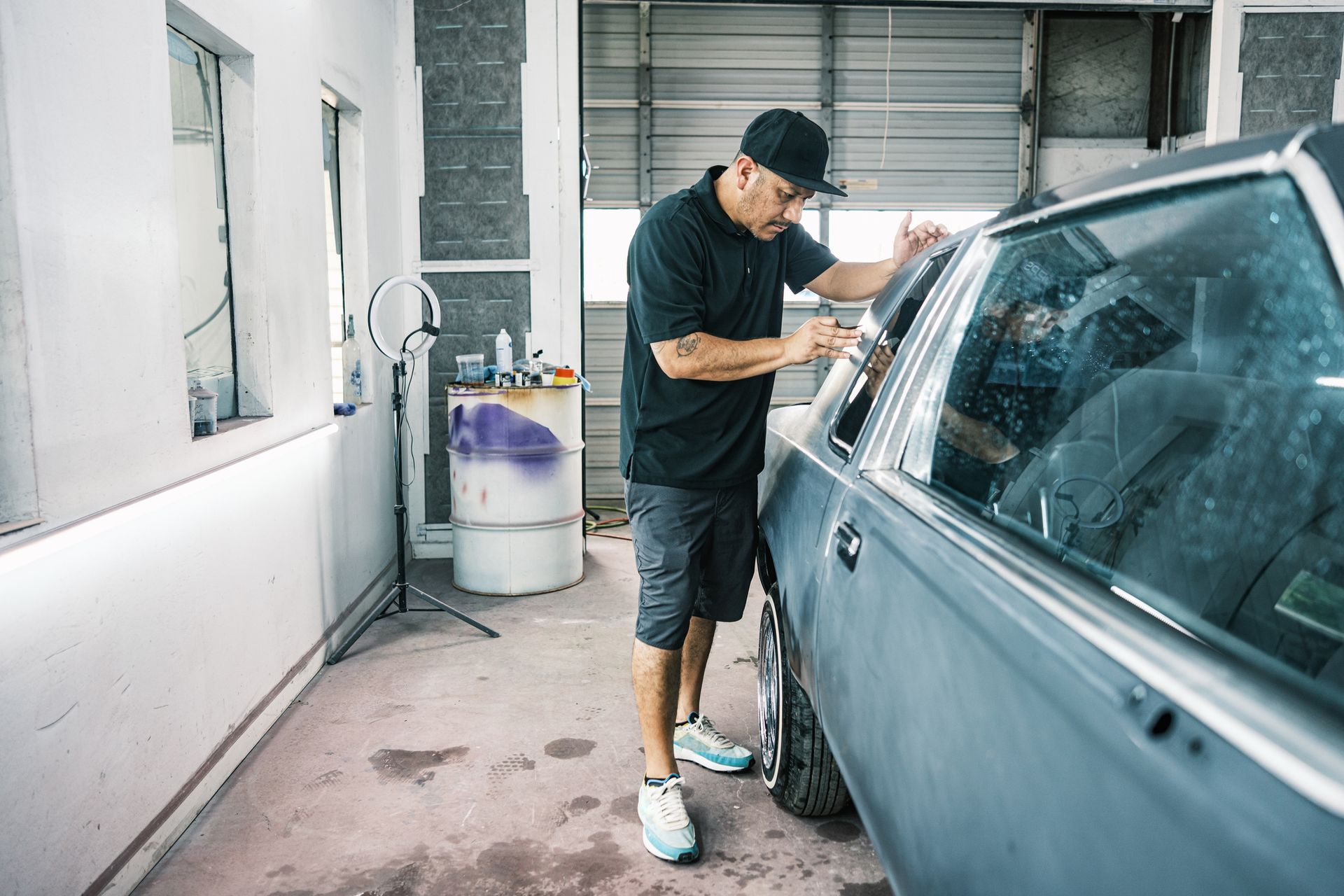 A man is working on a car in a garage.
