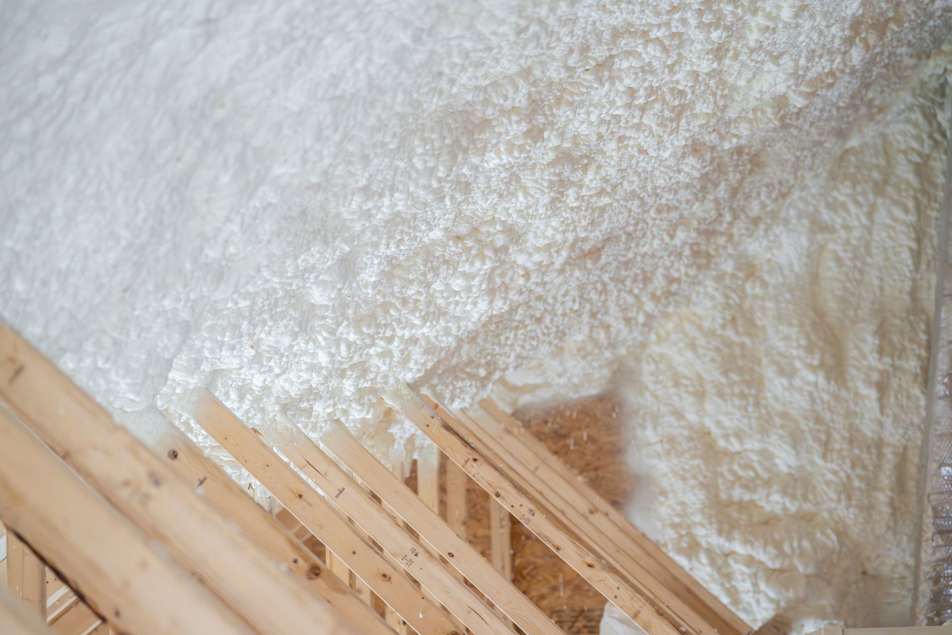 Construction worker spraying house insulation.