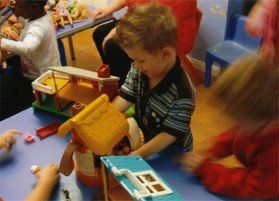 Little boy building a lego house