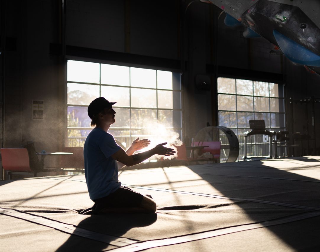 Figure in climbing gym chalking hands