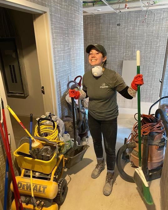 A person is using a vacuum cleaner to clean a carpet in a living room.