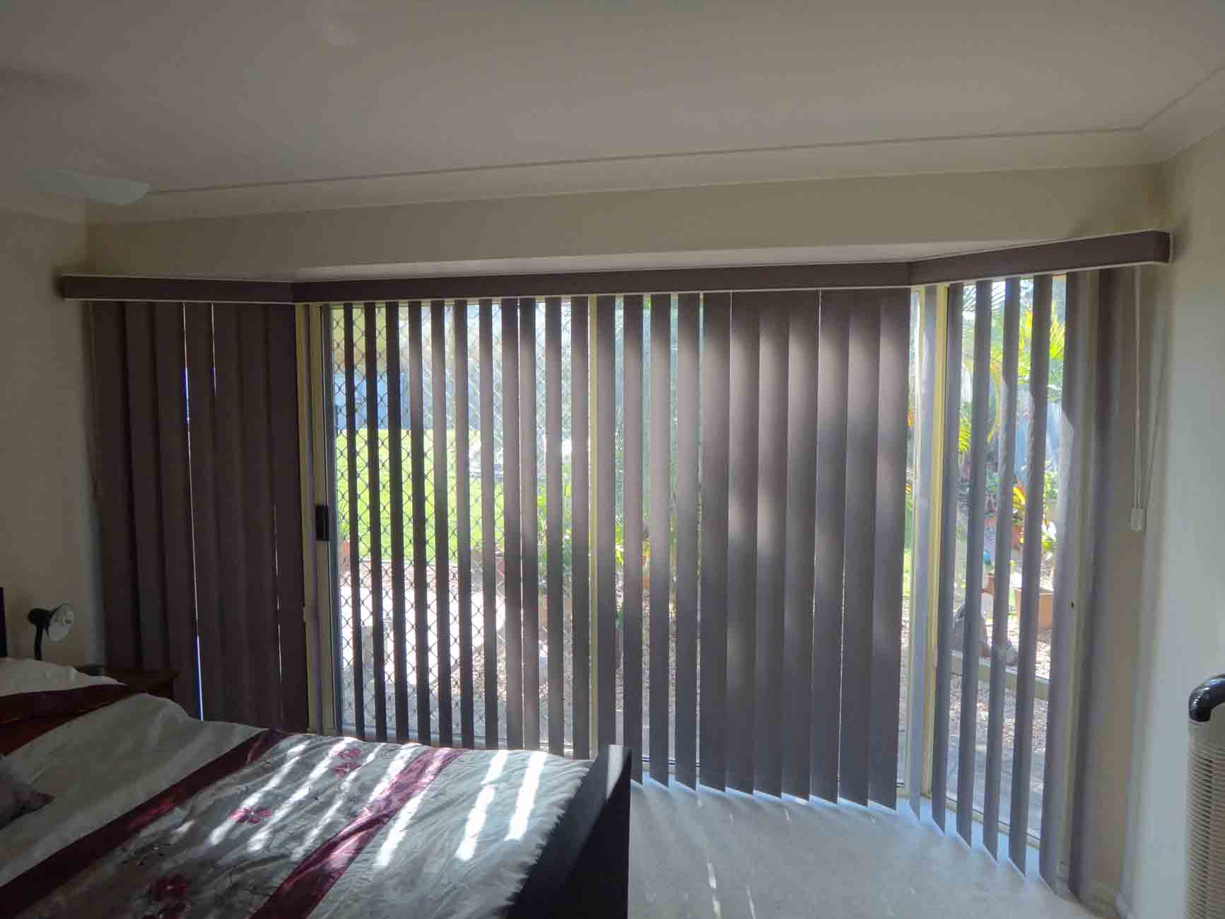 bedroom with dark beige vertical blinds