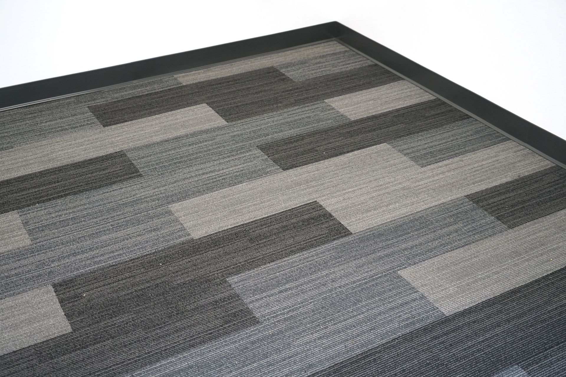 Dark gray and light gray rectangular patterned floor mat with a black border.