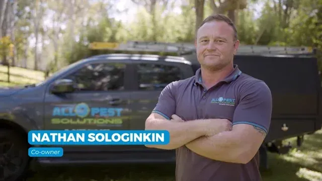 Man in polo shirt stands in front of a truck; 