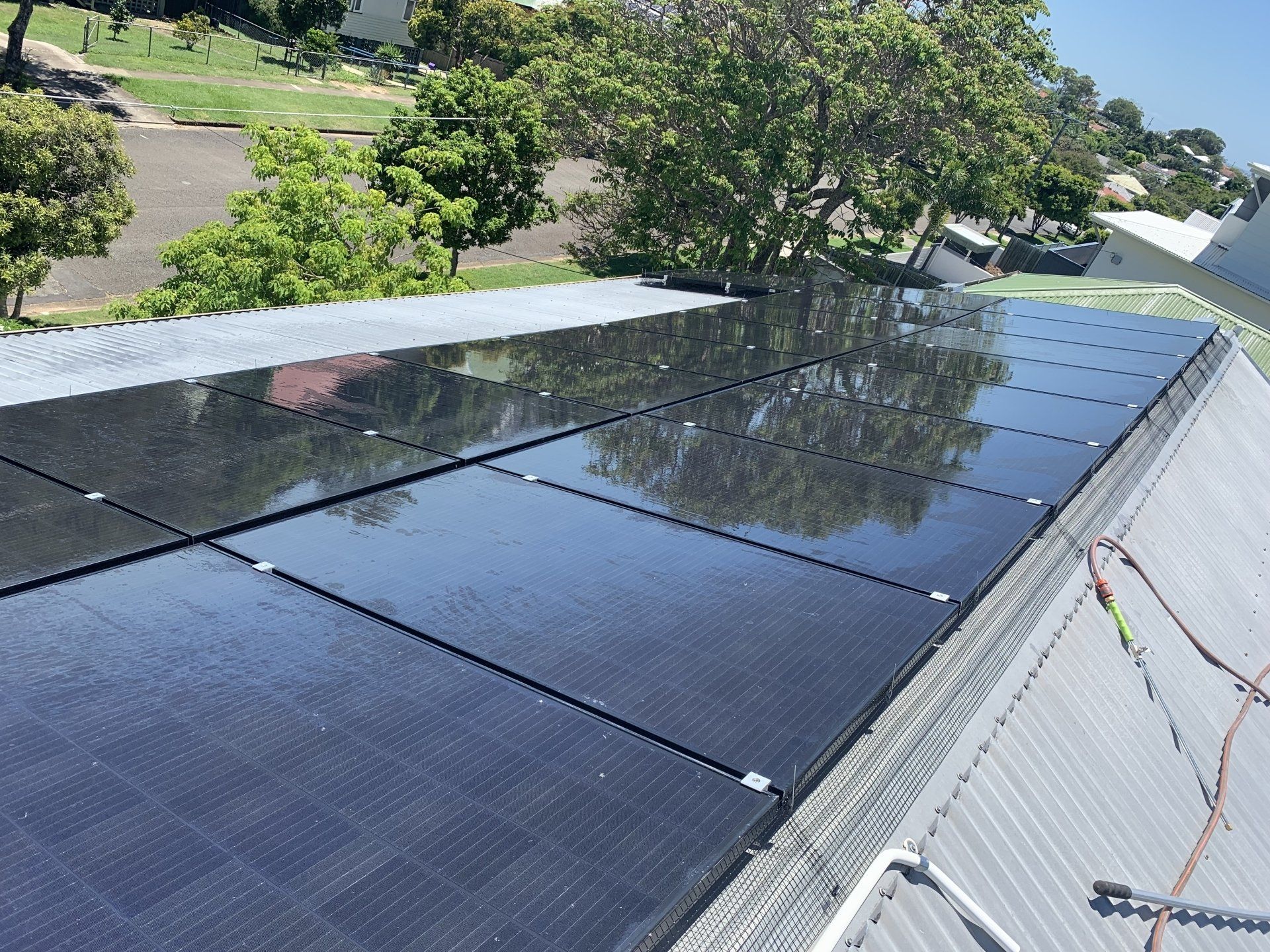 Solar panels installed on a metal roof, reflecting sunlight, outdoors.