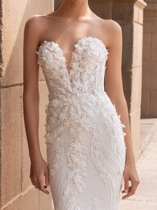 Strapless white beaded wedding gown with a deep V-neck and mermaid silhouette.