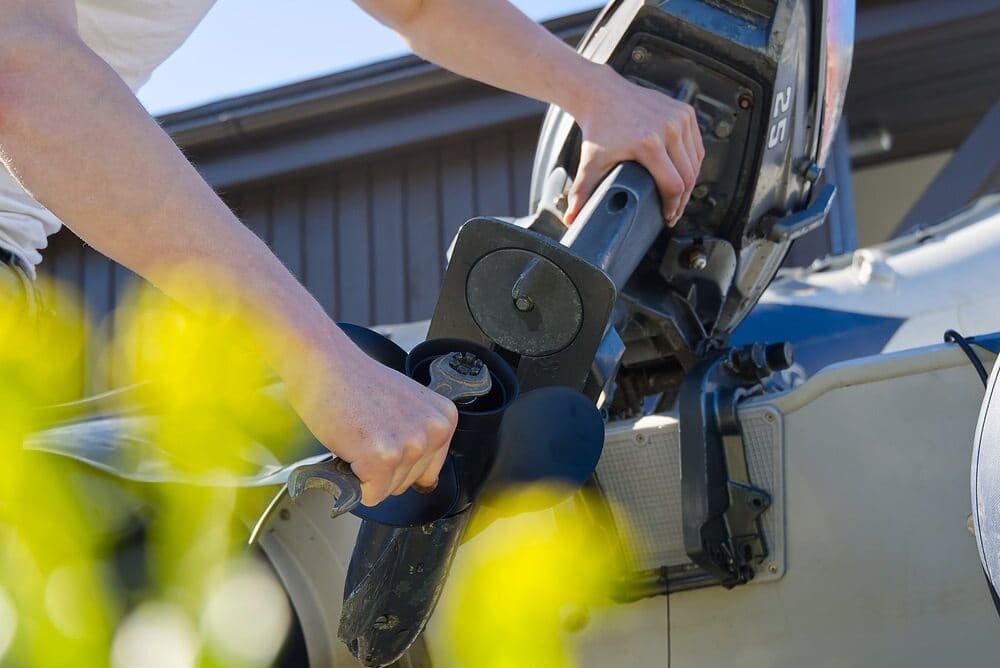 A Person is Holding the Handle of a Boat Engine — Clarence Valley Auto Electrical in South Grafton, NSW
