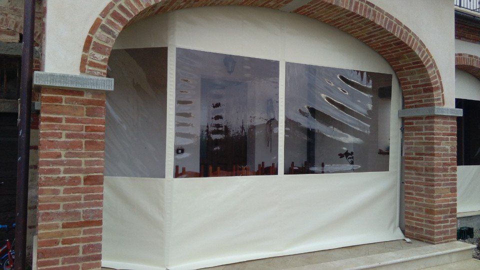 Un edificio in mattoni con una tenda bianca su un lato.