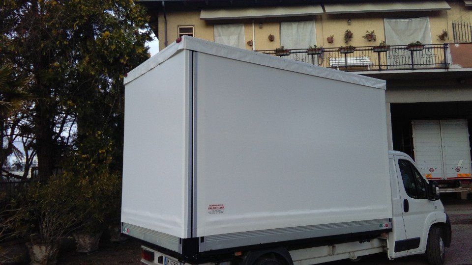 Un camion bianco è parcheggiato davanti a un edificio.