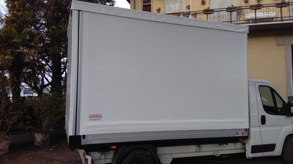 Un camion bianco è parcheggiato davanti a un edificio