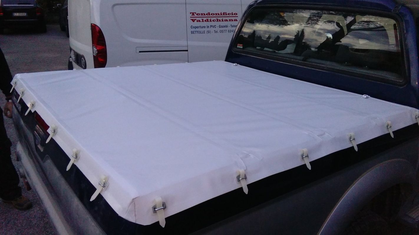 Un camion blu con un telo bianco sul cassone