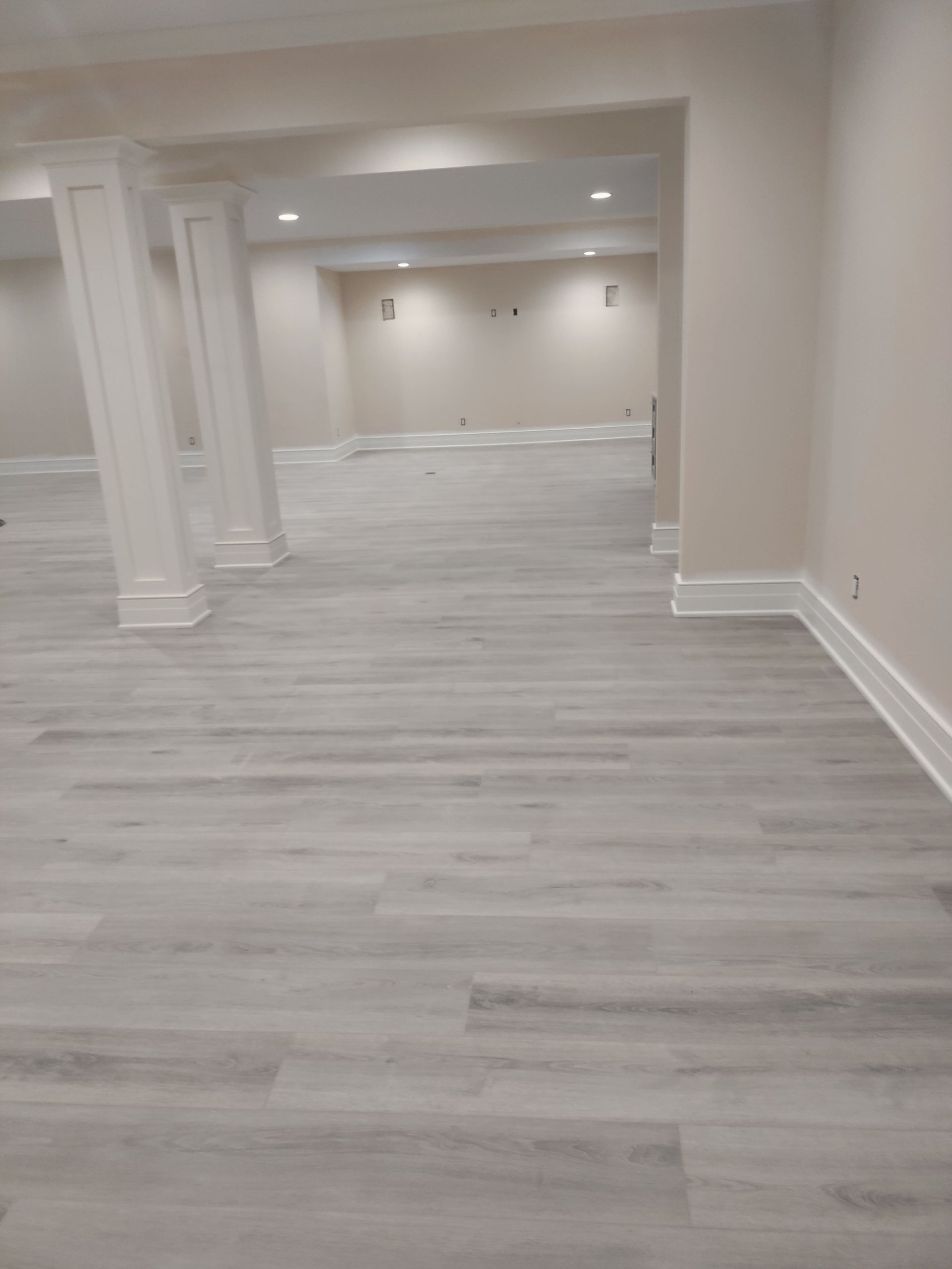 A basement with hardwood floors and white walls.