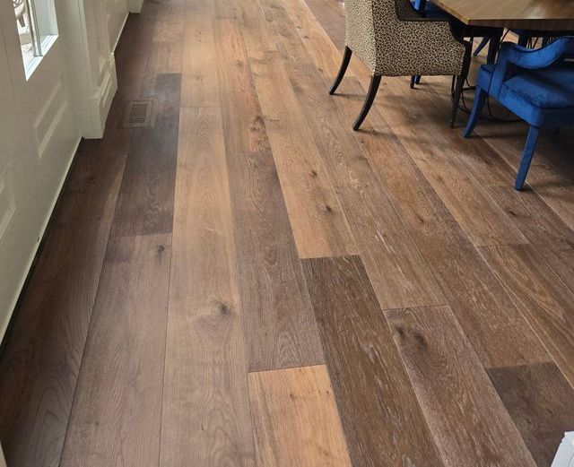 A wooden floor in a dining room with a table and chairs