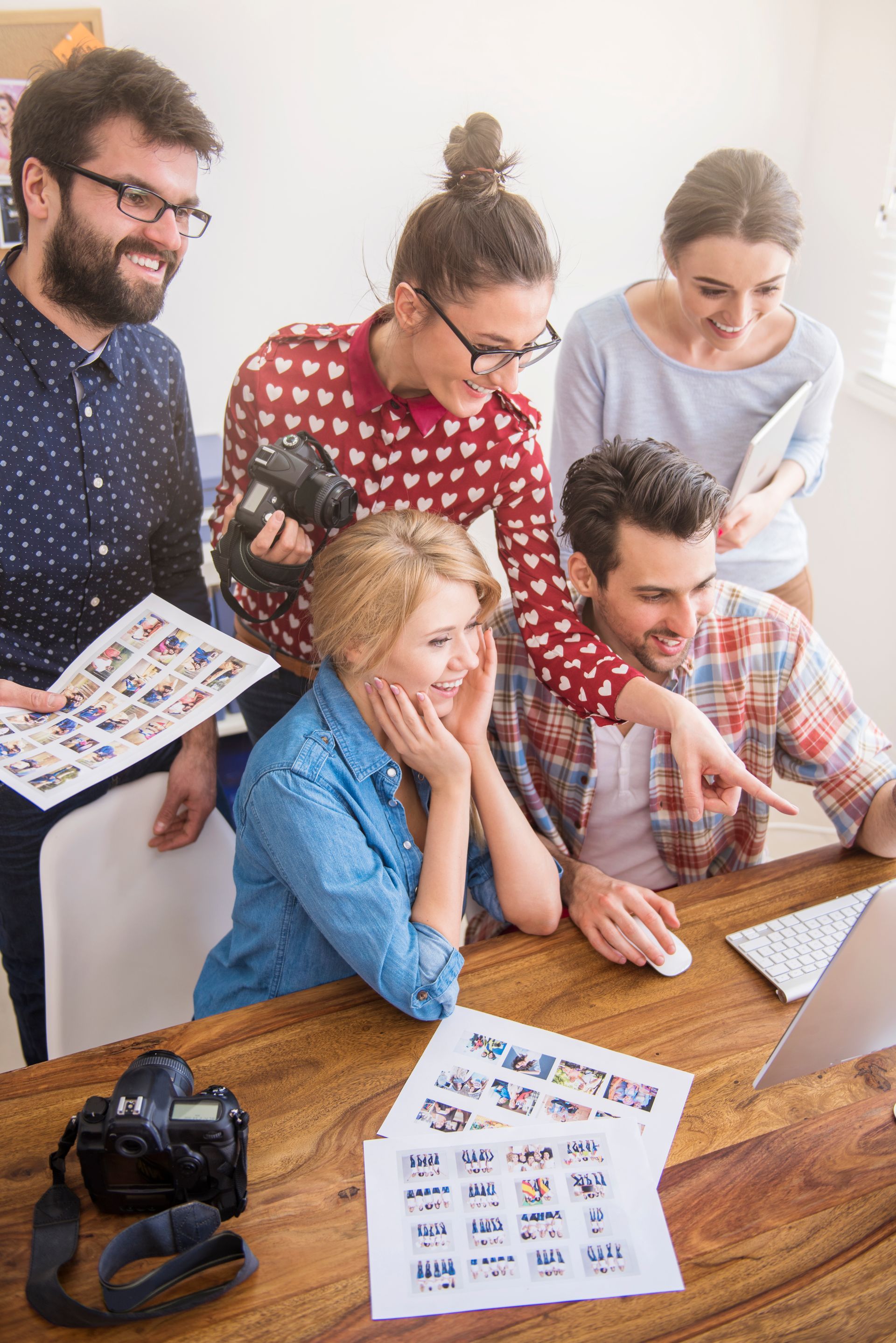 A group of people are sitting around a table looking at a computer screen.