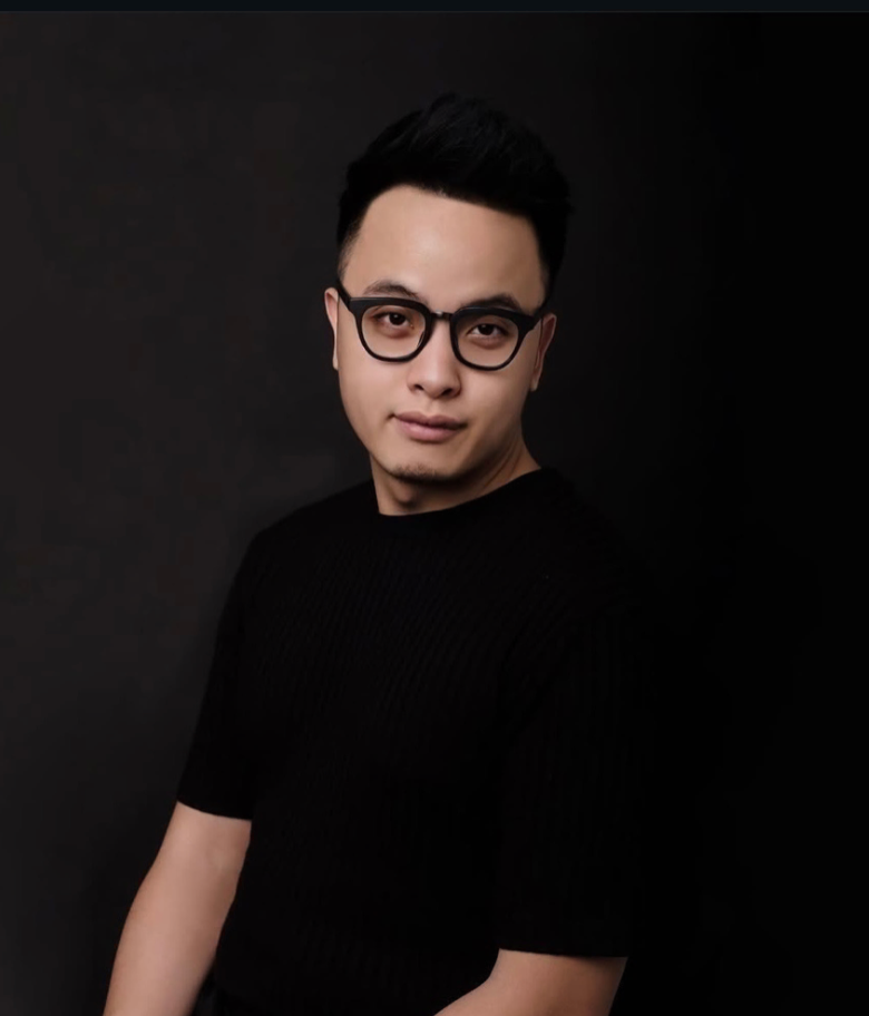 Person in a blue suit, back to the viewer, braided hair, against a cloudy sky.