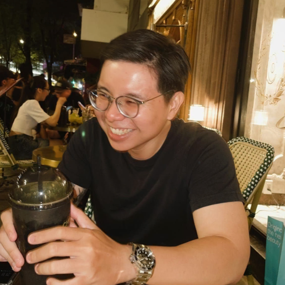 Person with orange hair wearing a light blue hoodie, looking toward the camera.