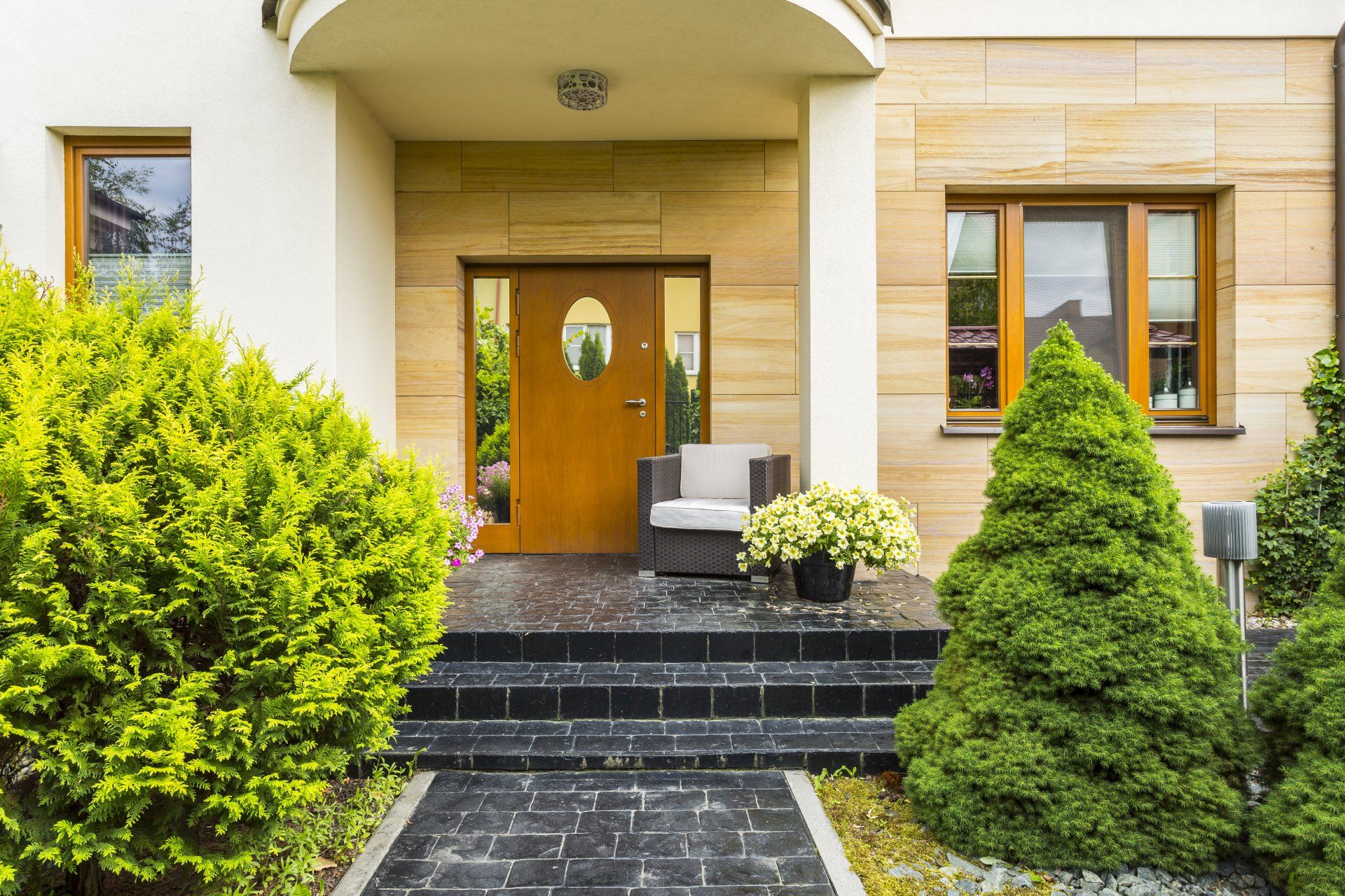 Big clapboard siding house In Yorba Linda CA. View of entrance porch with walkway green lawn and trimmed hedges