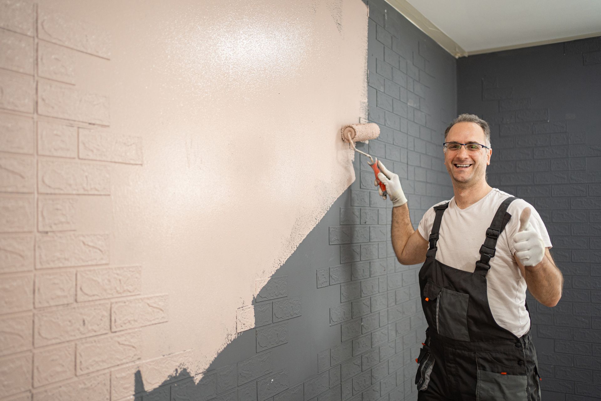 Man painting apartment wall using paint roller.
