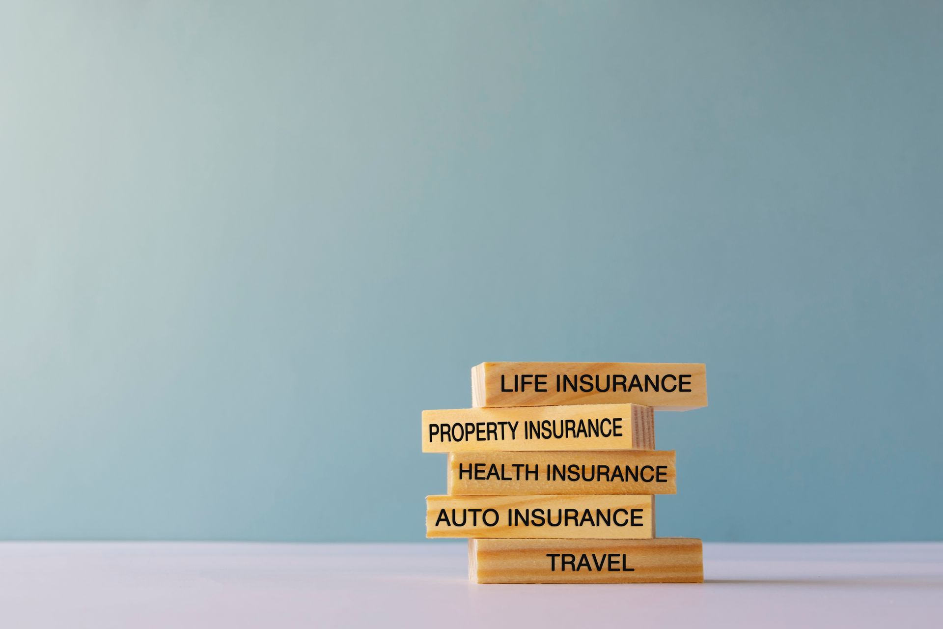 Stacked blocks label key insurance types on a clean blue backdrop.