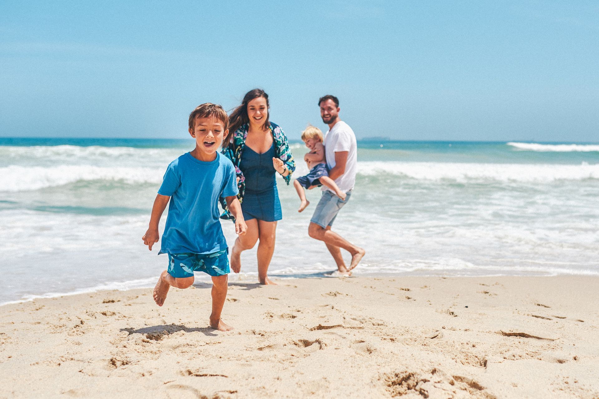 A family is running on the beach.