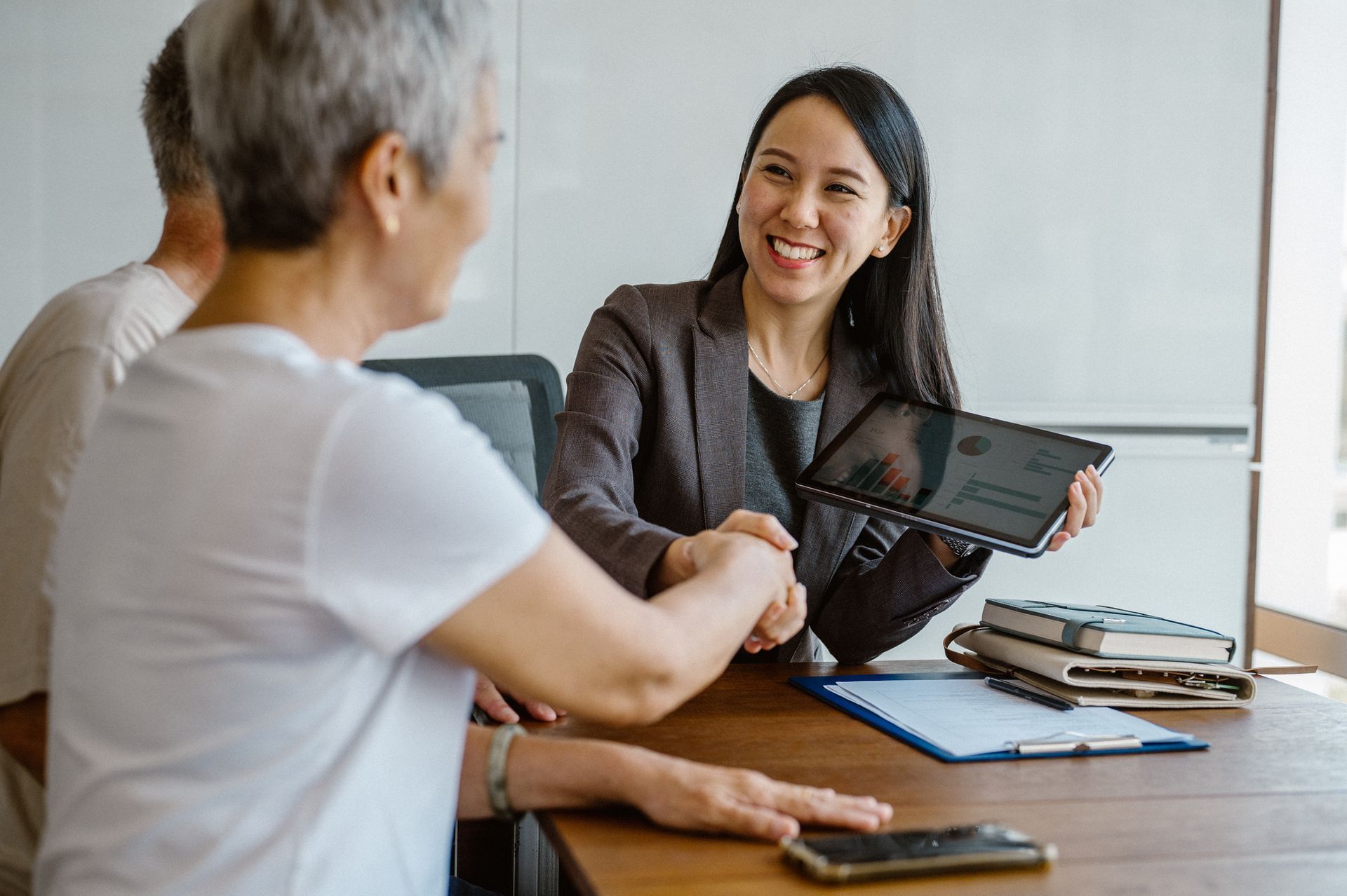 Insurance agent shaking hands with her client 