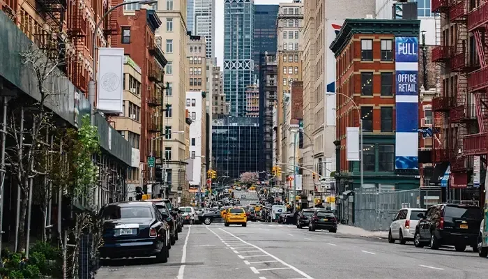A city street with a lot of cars parked on the side of it.