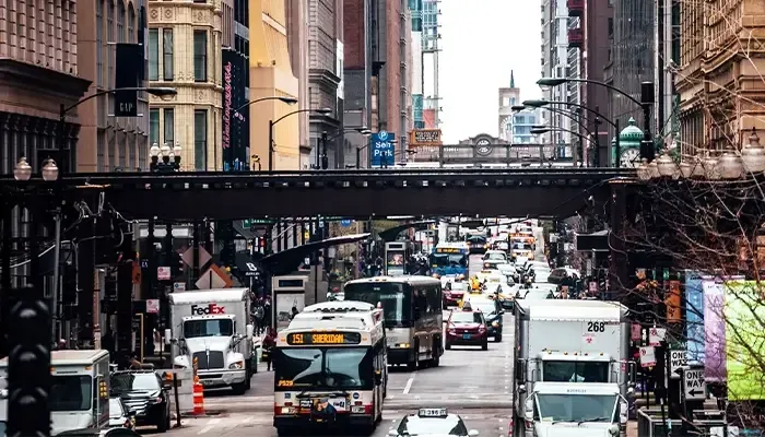 A busy city street with a bridge in the background.