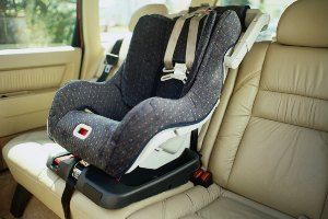 empty child car seat in back of car on sunny day