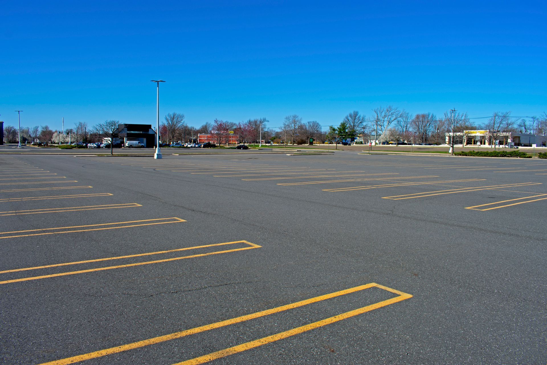 An empty parking lot with a blue sky in the background