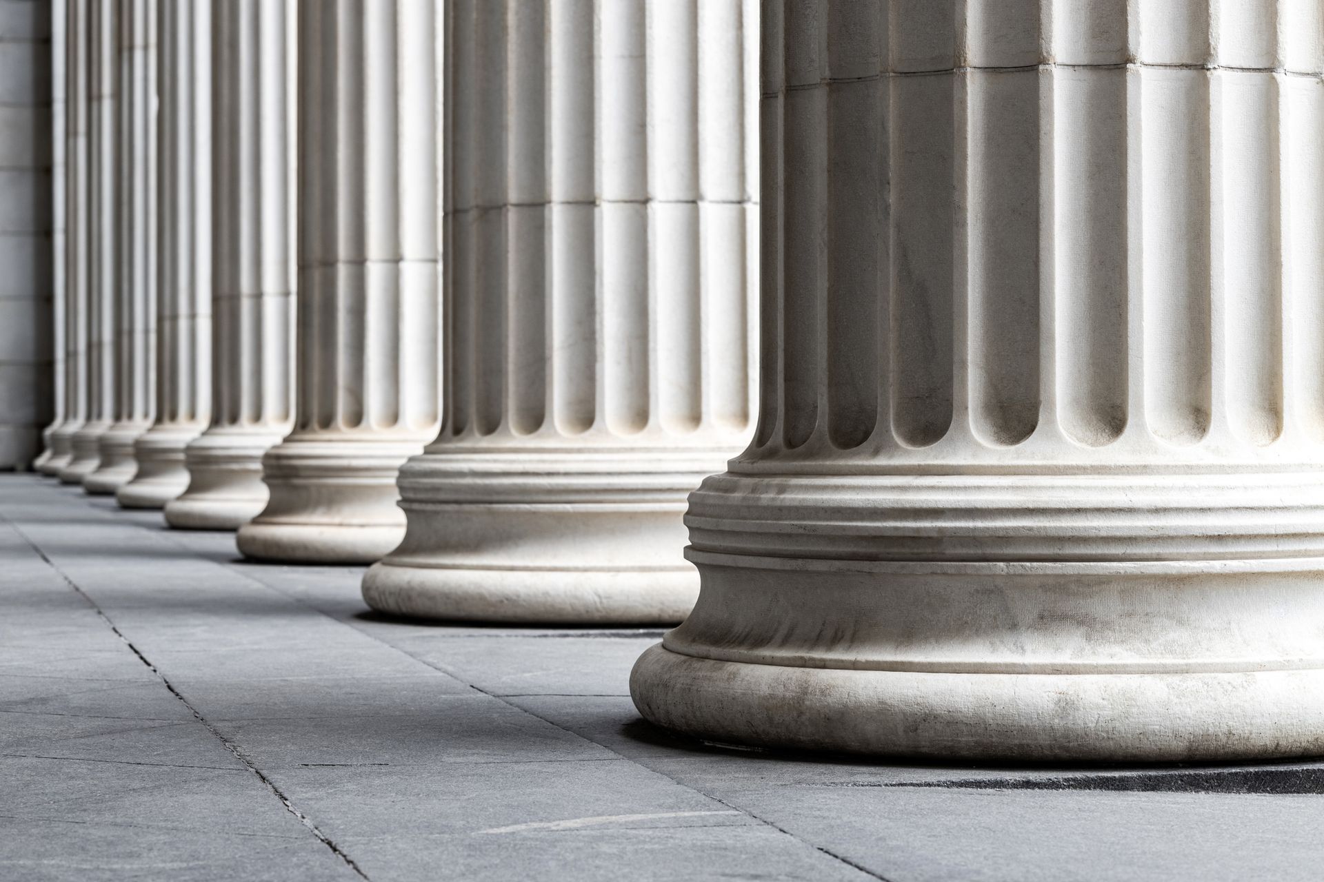 A row of columns are lined up in a row on a sidewalk.